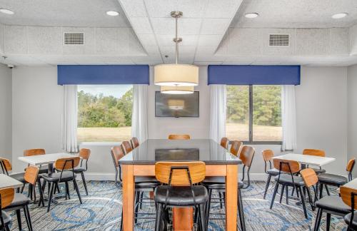 ein Konferenzraum mit Tischen und Stühlen und Fenstern in der Unterkunft The Windstar Hotel - Emerald Isle, Swansboro in Cedar Point