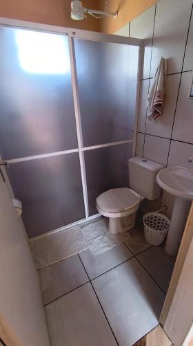 a bathroom with a shower and a toilet and a sink at Pousada da Dinda - Casa Familiar in São Gabriel