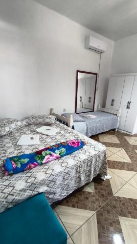 a room with two beds and a mirror at Pousada da Dinda - Casa Familiar in São Gabriel