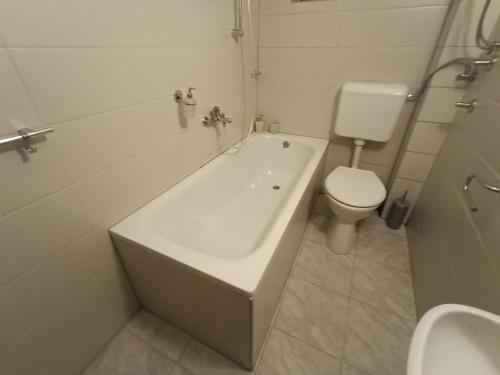 un bagno con una vasca bianca e un water di Vlasic Relax a Vlasic