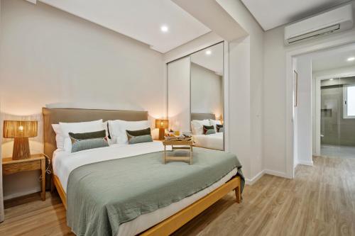 a bedroom with a large bed with a table on it at Modern Flat Just Steps From Shore in Ponta do Sol