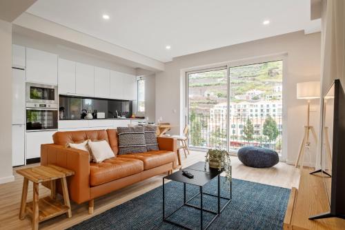a living room with a couch and a table at Modern Flat Just Steps From Shore in Ponta do Sol