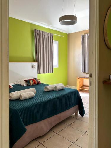 a bedroom with a bed with green walls at Village Creole in Les Trois-Îlets