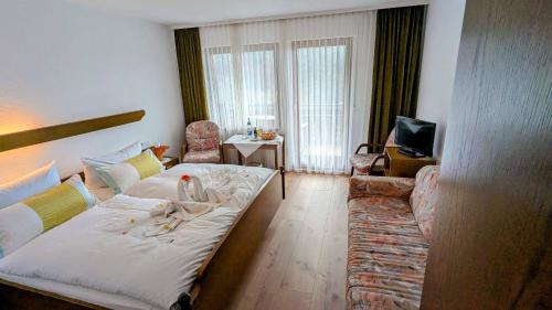 een woonkamer met een bed en een bank bij Decker's Bio Hotel zum Lamm in Baiersbronn