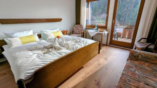 a bedroom with a large bed with white sheets at Decker's Bio Hotel zum Lamm in Baiersbronn