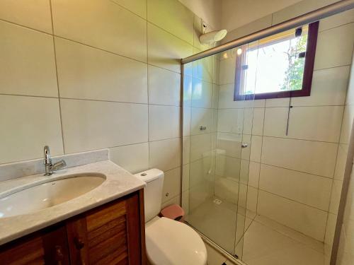 a bathroom with a shower and a toilet and a sink at Casa Vila São Miguel in Itacaré