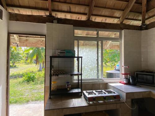 een keuken met een aanrecht met een fornuis en een raam bij MONITA VILLA in Tiputa