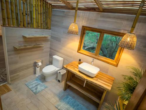 een badkamer met toilet, wastafel en raam bij Panama Kite Center in Punta Chame