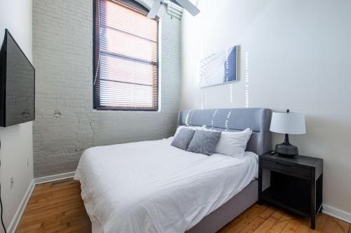 Schlafzimmer mit einem Bett mit blauem Kopfteil und einem Fenster in der Unterkunft Landing Stylish 1BD Courtyard Gym in Petersburg