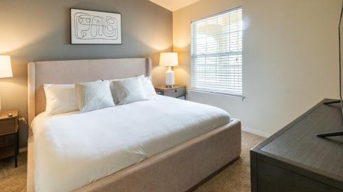 een slaapkamer met een wit bed en een raam bij Landing Amazing 2BD in Broken Arrow in Broken Arrow