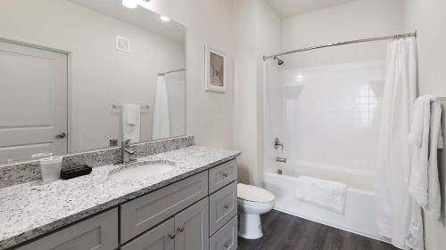 a white bathroom with a sink and a toilet at Landing Beautiful 1BD in North Fort Worth in Fort Worth