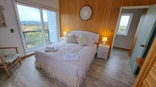 a bedroom with a bed with two towels on it at Casa Campo Chiloé in Chonchi