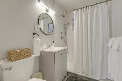 a white bathroom with a sink and a mirror at Walk to Shops and Dining Downtown Stuart Home! in Stuart