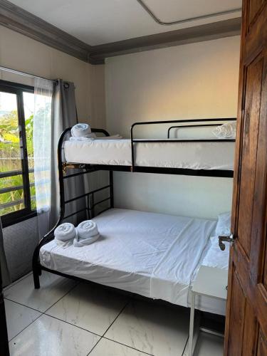 two bunk beds in a room with a window at Hospedaje Eli 09 in Pavones