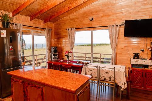 - une cuisine et une salle à manger avec vue sur l'océan dans l'établissement Cabañas Altos de Ñida, à Aytuy