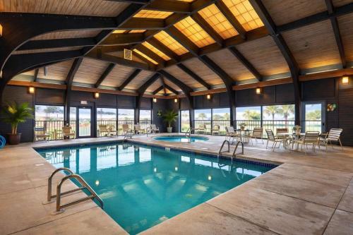 a large swimming pool with tables and chairs in a building at Windward Pointe 801- East corner-unit beachfront in Orange Beach