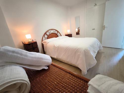 een slaapkamer met twee bedden met witte lakens bij Looking at the ocean sunset in Puerto de la Madera