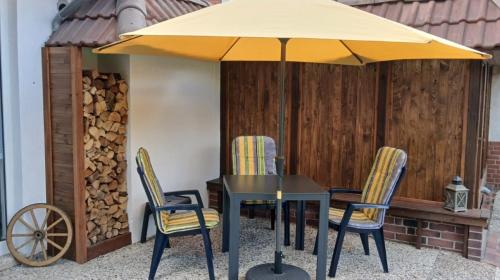 een tafel en stoelen onder een parasol op een terras bij Fewo Seestern in Bremerhaven