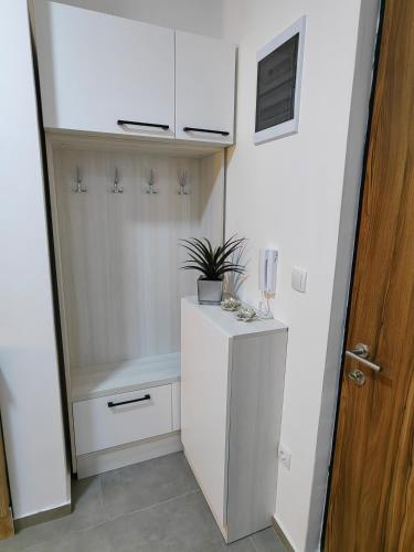 a white closet with a plant on top of it at Vidak apartman in Divčibare