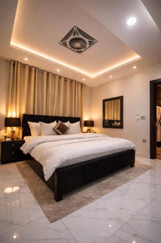 a large bedroom with a large bed with white sheets at LMY Residency - Bahria Town Lahore in Lahore