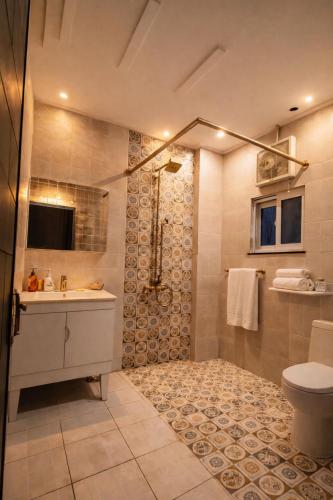 a bathroom with a shower and a sink and a toilet at LMY Residency - Bahria Town Lahore in Lahore