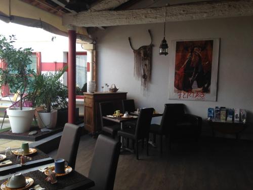 a restaurant with tables and chairs and a painting on the wall at Hotel Cote Patio in Nîmes