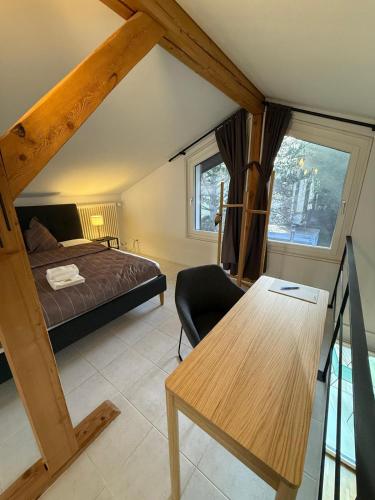 ein Schlafzimmer mit einem Bett und einem Schreibtisch in einem Zimmer in der Unterkunft LaVida Star Alpine Hideaway Thun, Sauna, free parking in Blumenstein