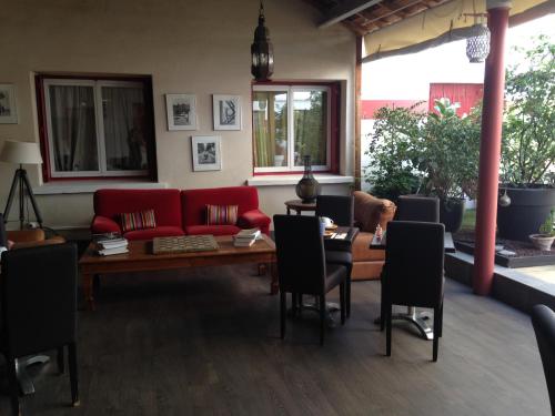 a living room with a red couch and a table at Hotel Cote Patio in Nîmes