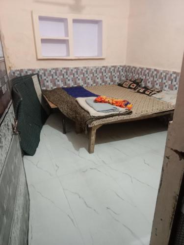 a small room with a bed and a window at Chaudhary dharamshala in Jāmb