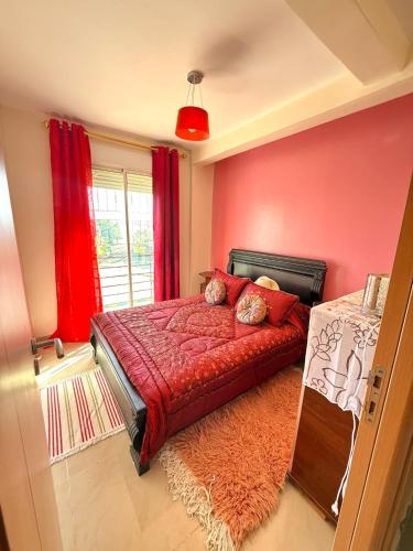 een slaapkamer met een rood bed en een raam bij Face à la Mer TANGER in Hauara