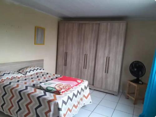 une chambre avec un lit et une armoire en bois dans l'établissement Casa espaçosa, à Garanhuns