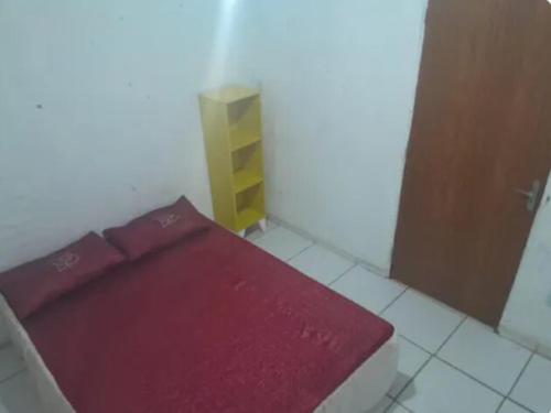 - un lit rouge dans une chambre avec porte dans l'établissement Casa espaçosa, à Garanhuns