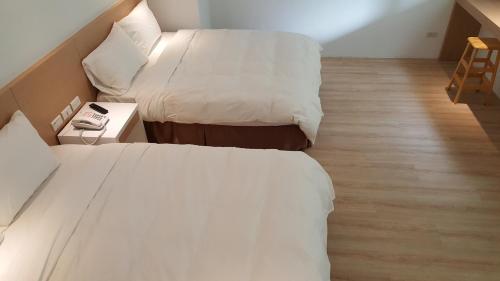 a hotel room with two beds and a night stand at Ze Hu B&B in Yuchi