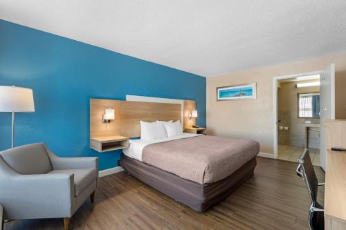 ein Hotelzimmer mit einem Bett und einem Stuhl in der Unterkunft Quality Inn & Suites Conference Center in New Port Richey