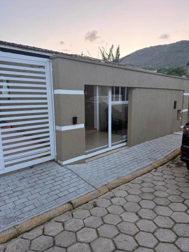 a house with a garage with a car parked in front at Casa charmosa praia Itapema in Itapema