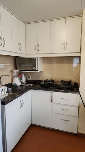 een keuken met witte kasten en een kookplaat oven bij Plaza murillo in La Paz