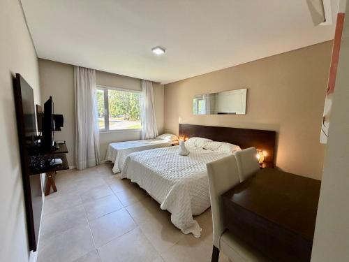 una camera da letto con due letti e una finestra di Rincón del Sol - Suite 09 a Pinamar