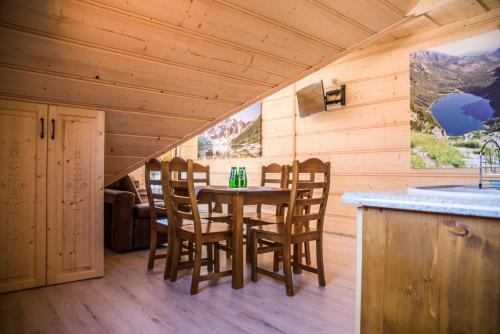 a dining room with a table and chairs in a cabin at Apartamenty i pokoje Pod Limbami - sauna, tężnia in Bukowina Tatrzańska