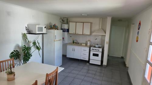 eine Küche mit weißen Geräten und einem Tisch und einem Tisch und einem Esszimmer in der Unterkunft Valle del Río Chico in Gobernador Gregores