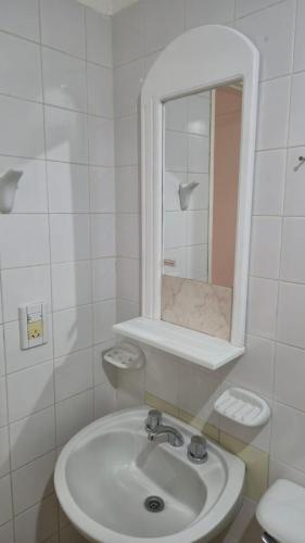 a white bathroom with a sink and a mirror at Valle del Río Chico in Gobernador Gregores