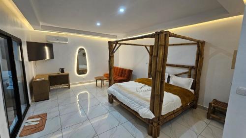 a bedroom with a wooden canopy bed in a room at Ayooka Beach Residence Grand Bassam in Grand-Bassam