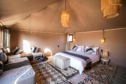 ein Schlafzimmer mit zwei Betten in einem Zelt in der Unterkunft sand luxury camp in Merzouga