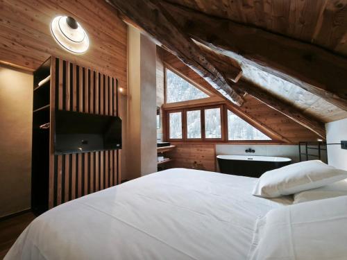 - une chambre avec un grand lit blanc et un lavabo dans l'établissement Chalet prestige 14 pers au pied des pistes, à Ceillac