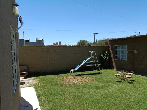 een speeltuin in een tuin met een glijbaan bij Hospedaje BellaVilla in Bell Ville