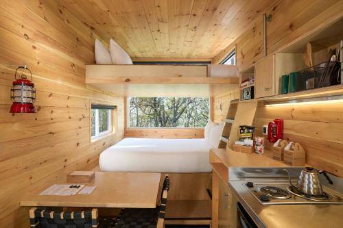 een kleine keuken met een bed in een tiny house bij Postcard Cabins Starved Rock, Outdoor Collection by Marriott Bonvoy in Ottawa