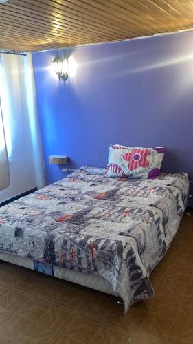 un lit dans une chambre avec un mur bleu dans l'établissement Habitaciones Luna IX, à Chía