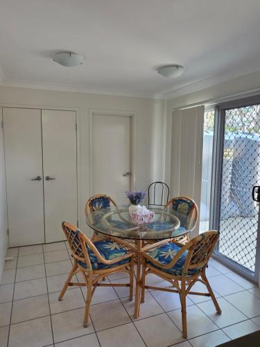 ein Esszimmer mit Glastisch und Stühlen in der Unterkunft Mango Hill 3 Bedroom Family Accommodation in North Lakes
