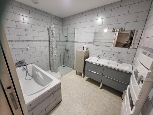 a bathroom with a tub and a sink and a bath tub at Loubarie 
