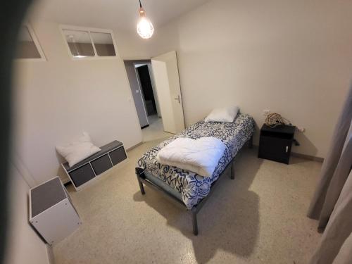 een kleine slaapkamer met een bed en een nachtkastje bij Loubarie 