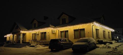 een huis met kerstverlichting in de sneeuw bij Lawendowy Dworek in Bałtów